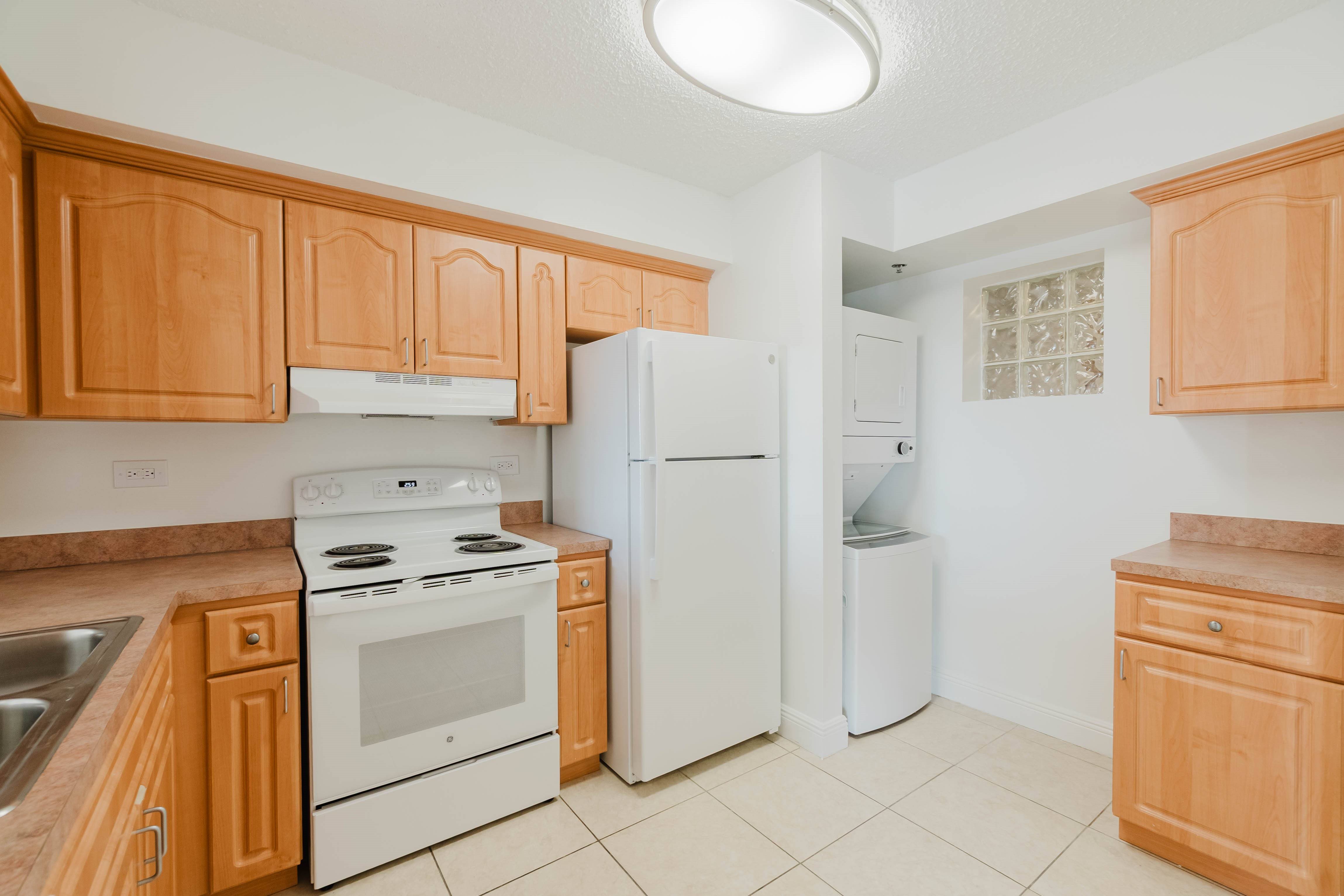 A kitchen with wooden cabinets and white appliances.